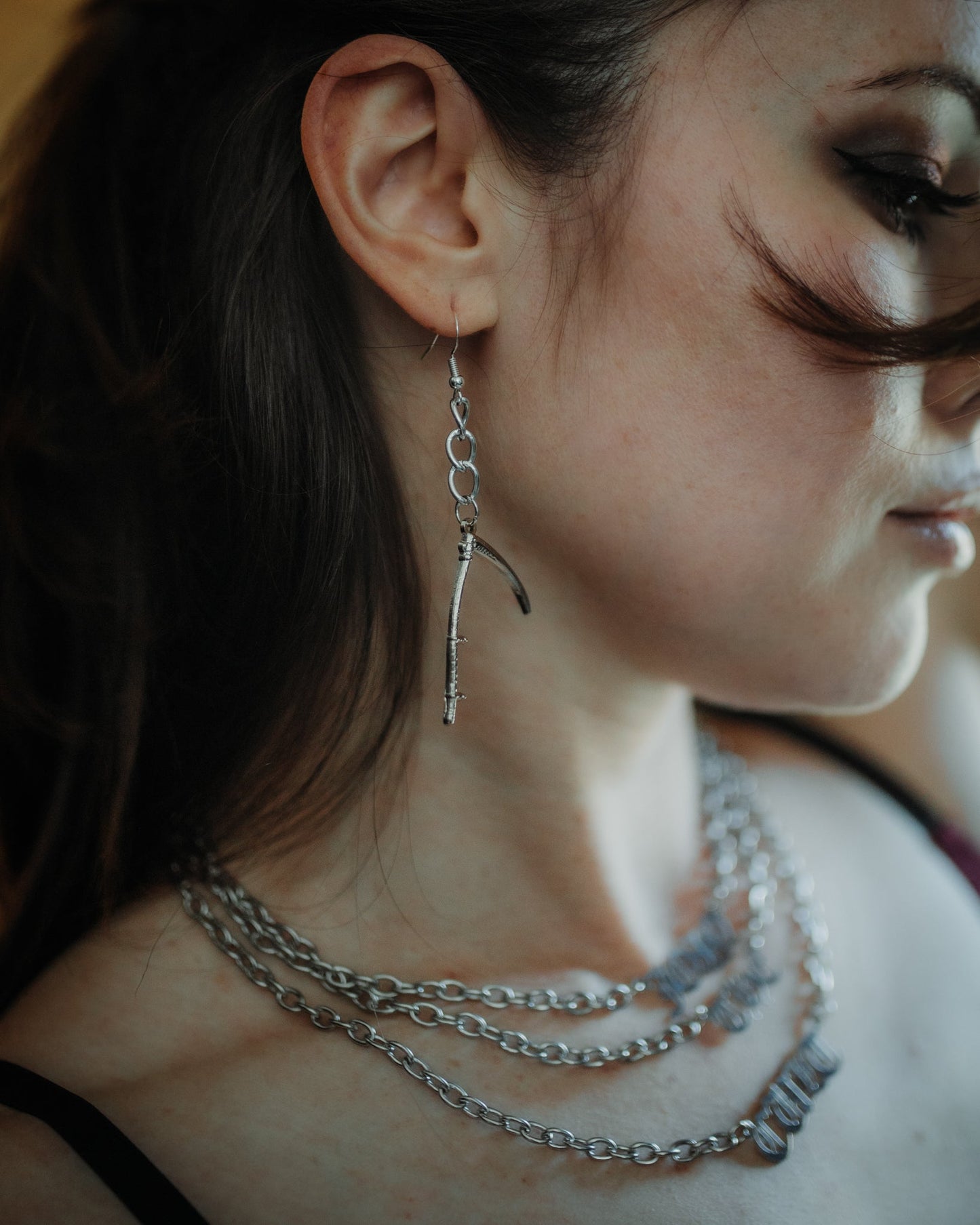 Scythe silver drop earrings styled against a dark background, The Pretty Cult