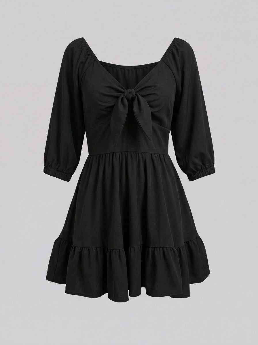 Ghost mannequin view of the Molly Mini dress in solid black, showing the tie-front bodice and tiered ruffle hem.