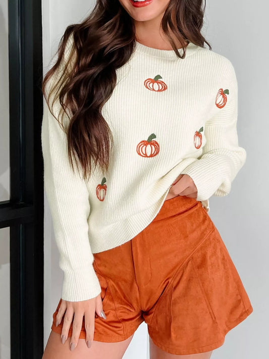Close-up of the embroidered pumpkins on the cream white oversized knit sweater