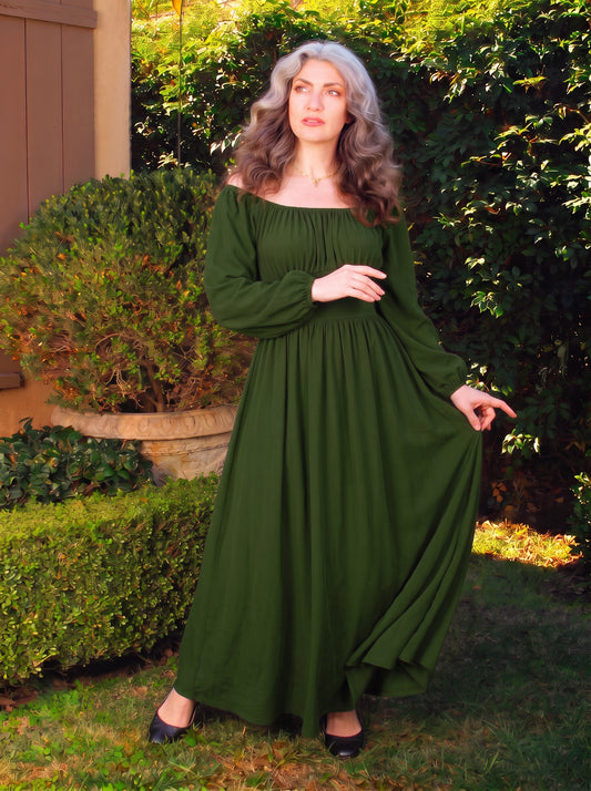 Hunter Green Swann Maxi Dress worn off the shoulder, showing the gathered neckline and the full skirt falling to the floor