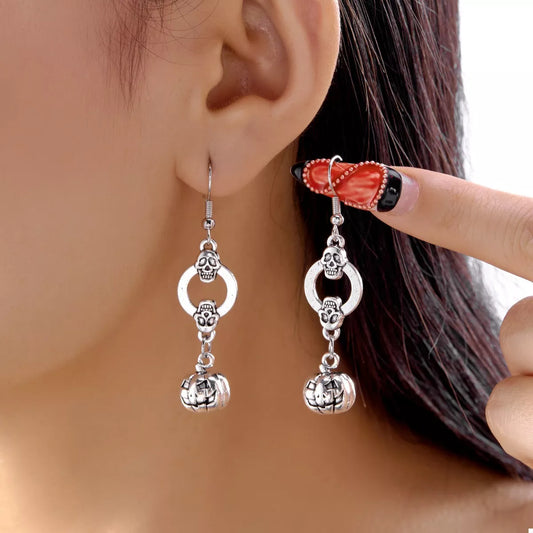 Close-up of the silver skull stud and jack-o'-lantern charm