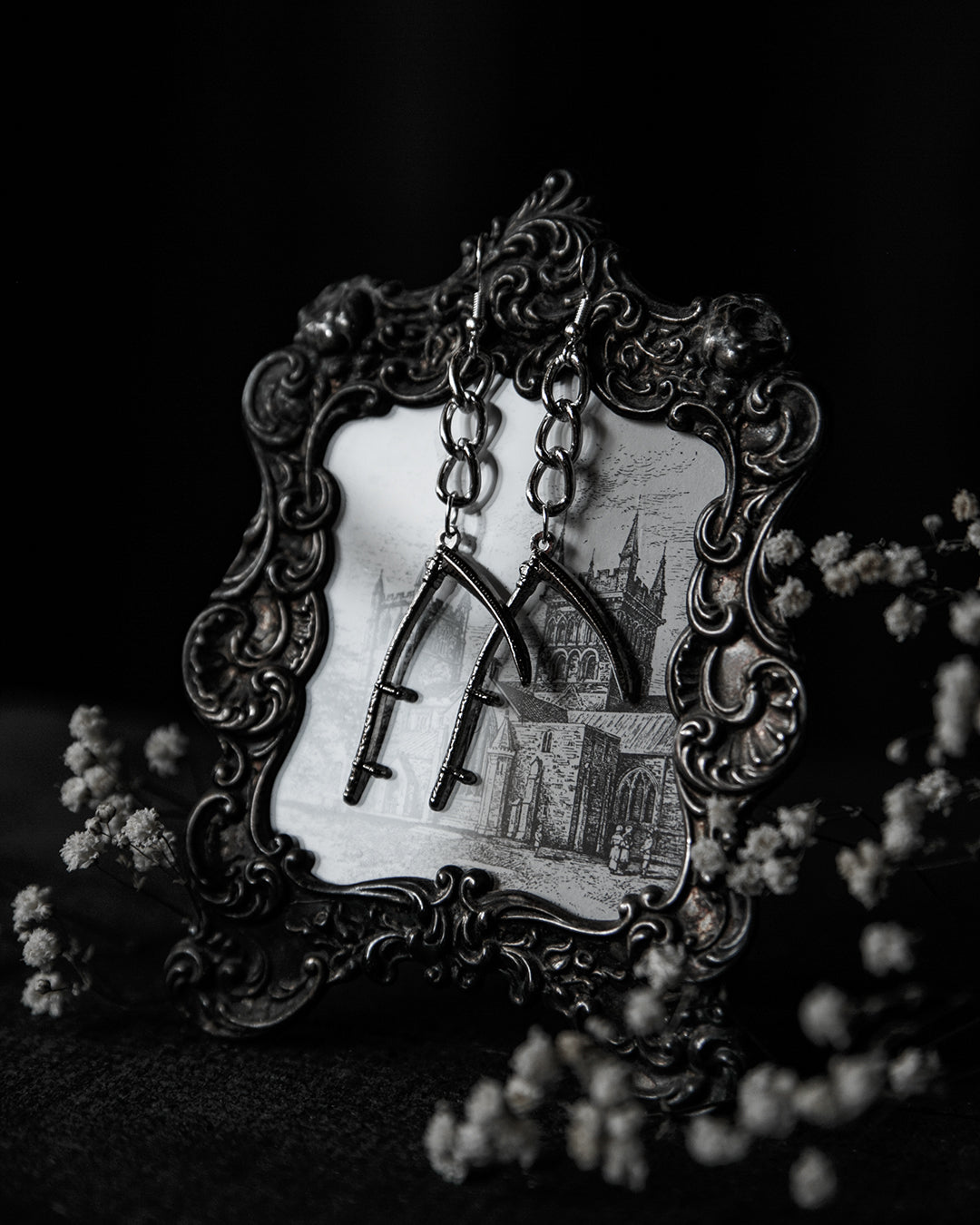 Close-up of the silver scythe charm and oversized chain links, The Pretty Cult