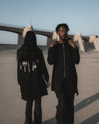 Black longline zip hoodie with metallic silver weapons print on the back