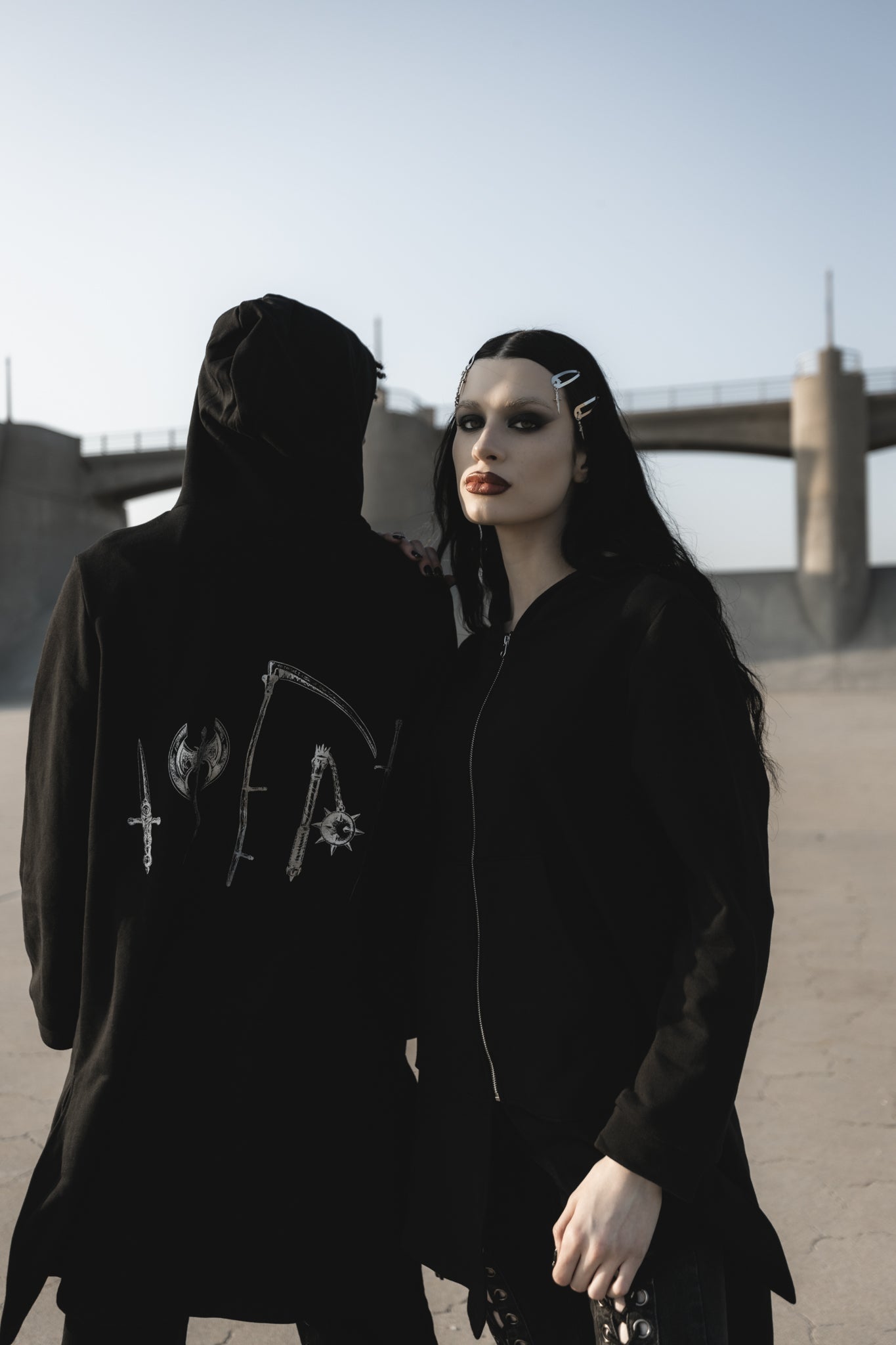 Metallic silver weapons print detail on the black hoodie back