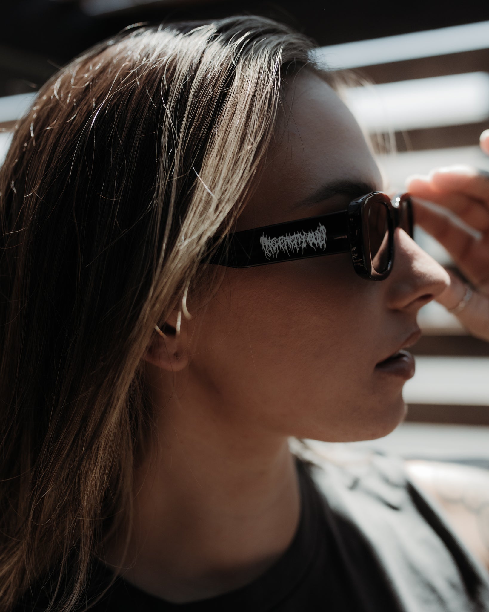 Black Metal black sunglasses shown from the side in daylight, The Pretty Cult