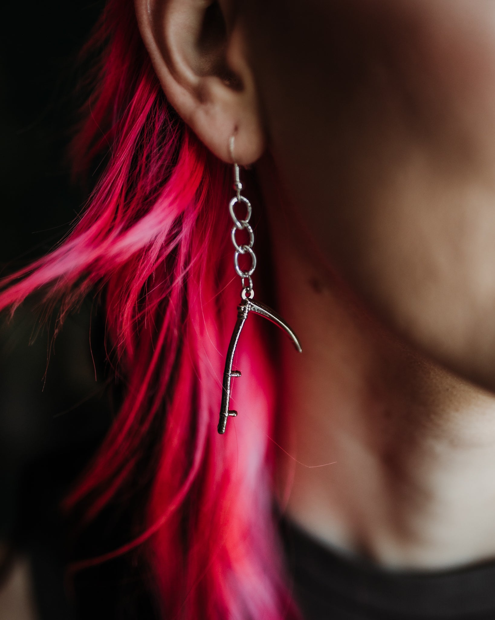 Model wearing the silver Scythe drop earring on oversized chain links, by The Pretty Cult