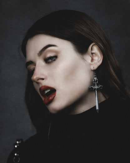 Model wearing the Woe Blade antiqued silver sword earring, by The Pretty Cult