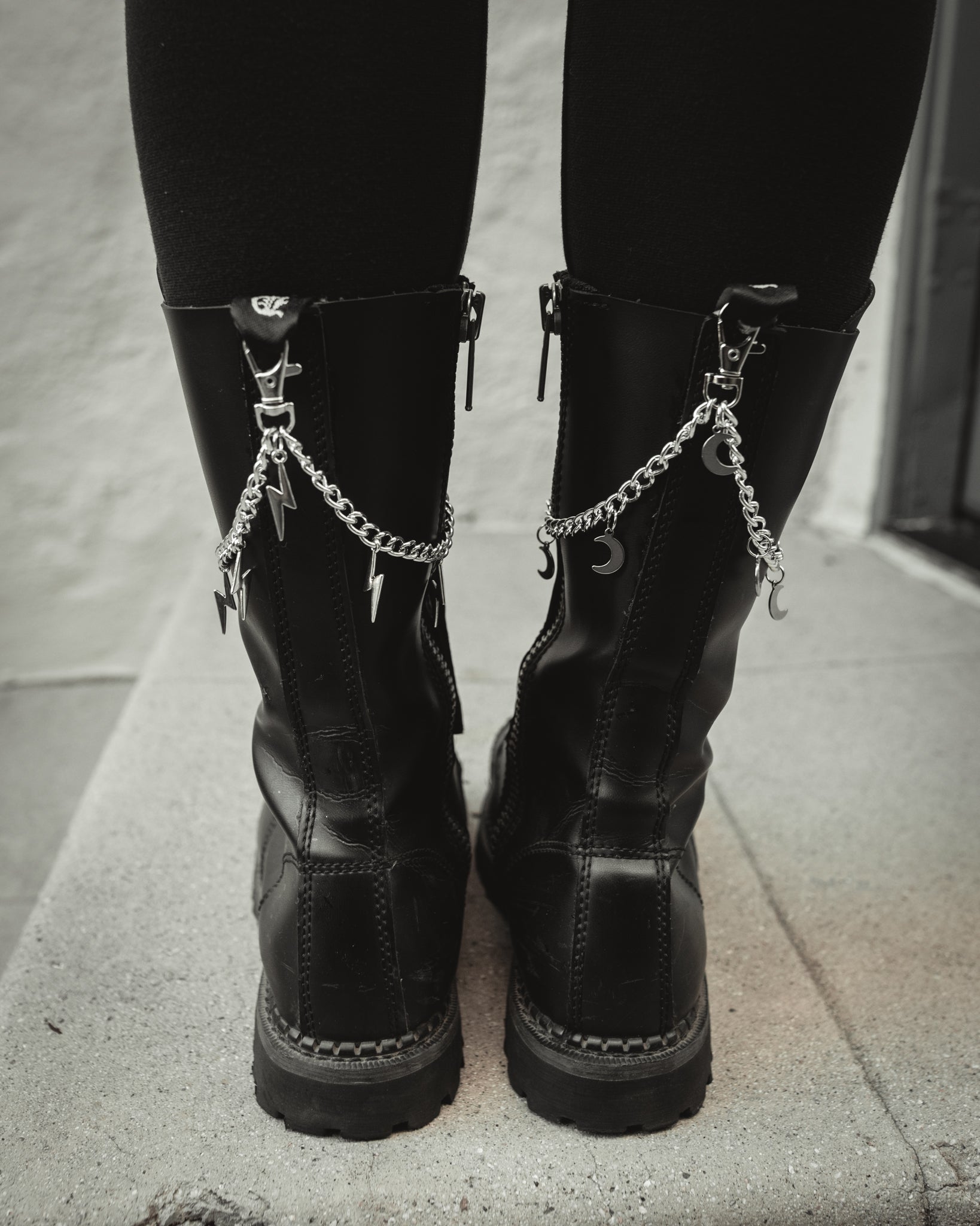 Silver crescent moon boot charm chain clipped to a black combat boot
