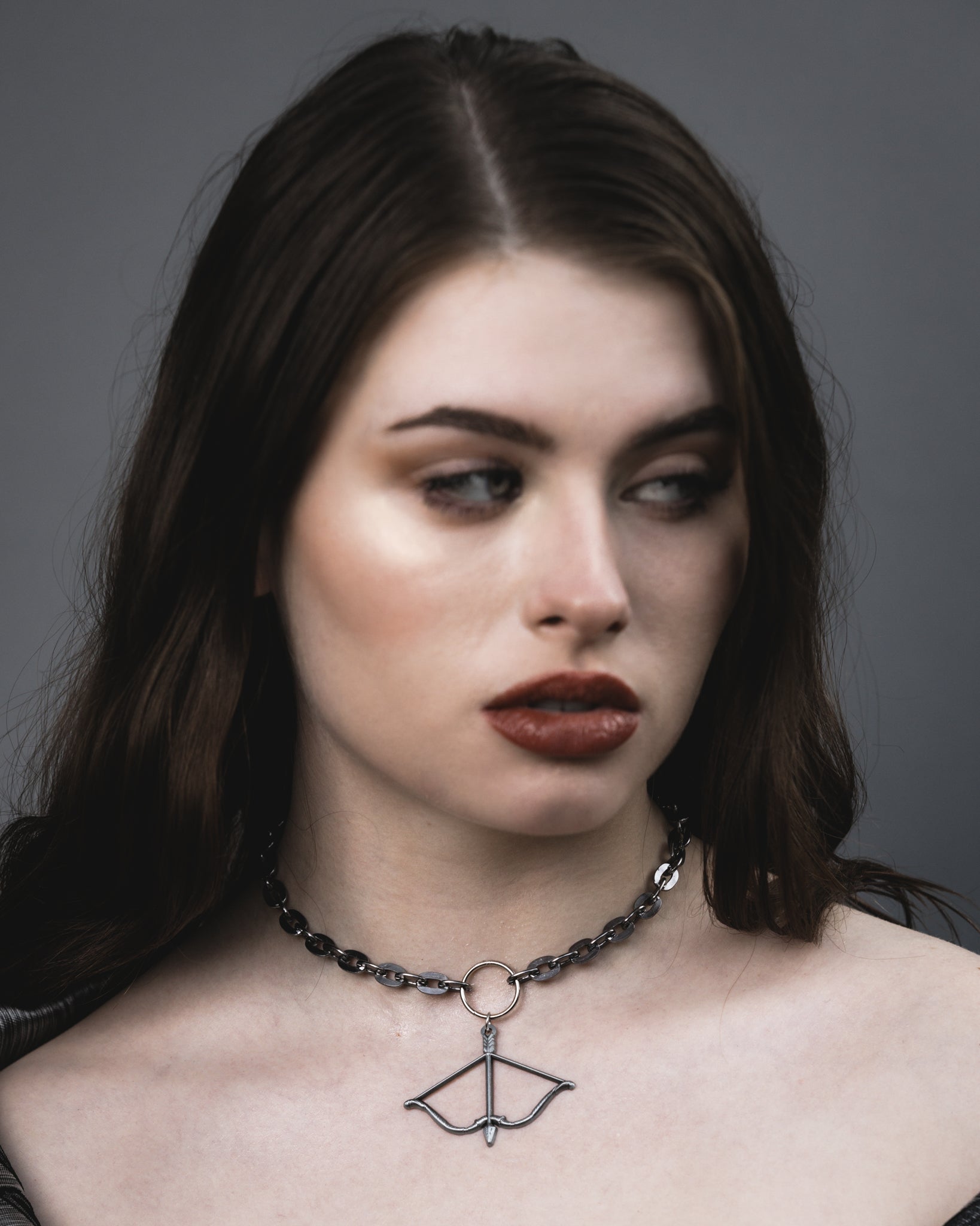 Close-up of the silver bow and arrow pendant and O-ring on the Aether choker, The Pretty Cult