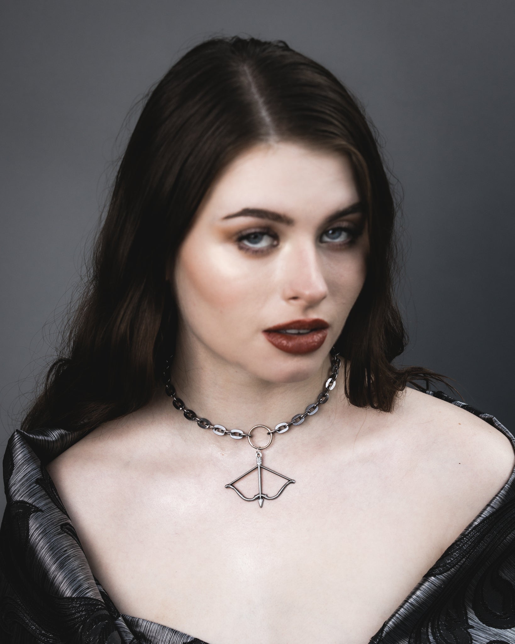 Front view of the silver Aether bow and arrow choker on a steel chain, The Pretty Cult