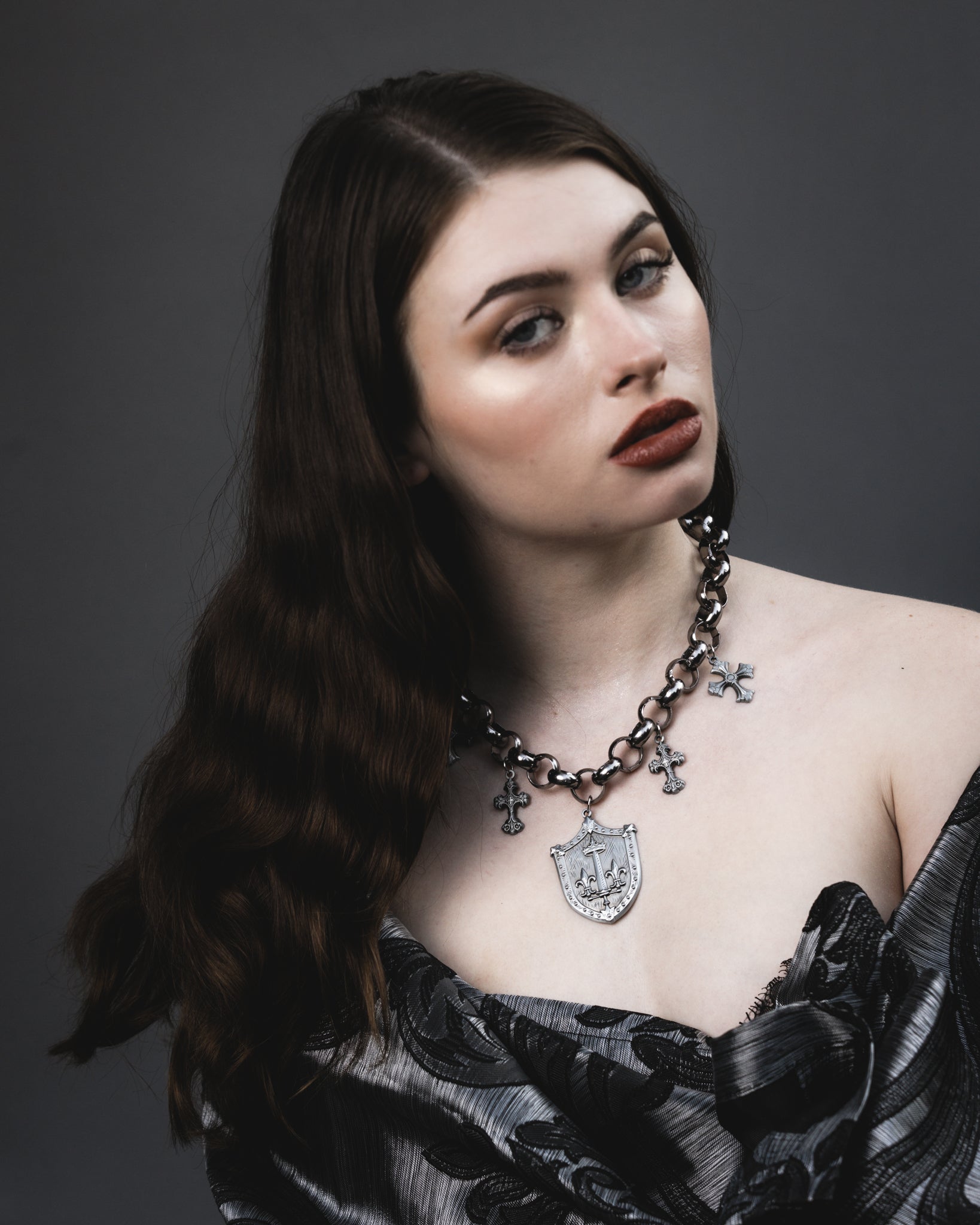 Close up of the Le Fay silver shield pendant and crosses