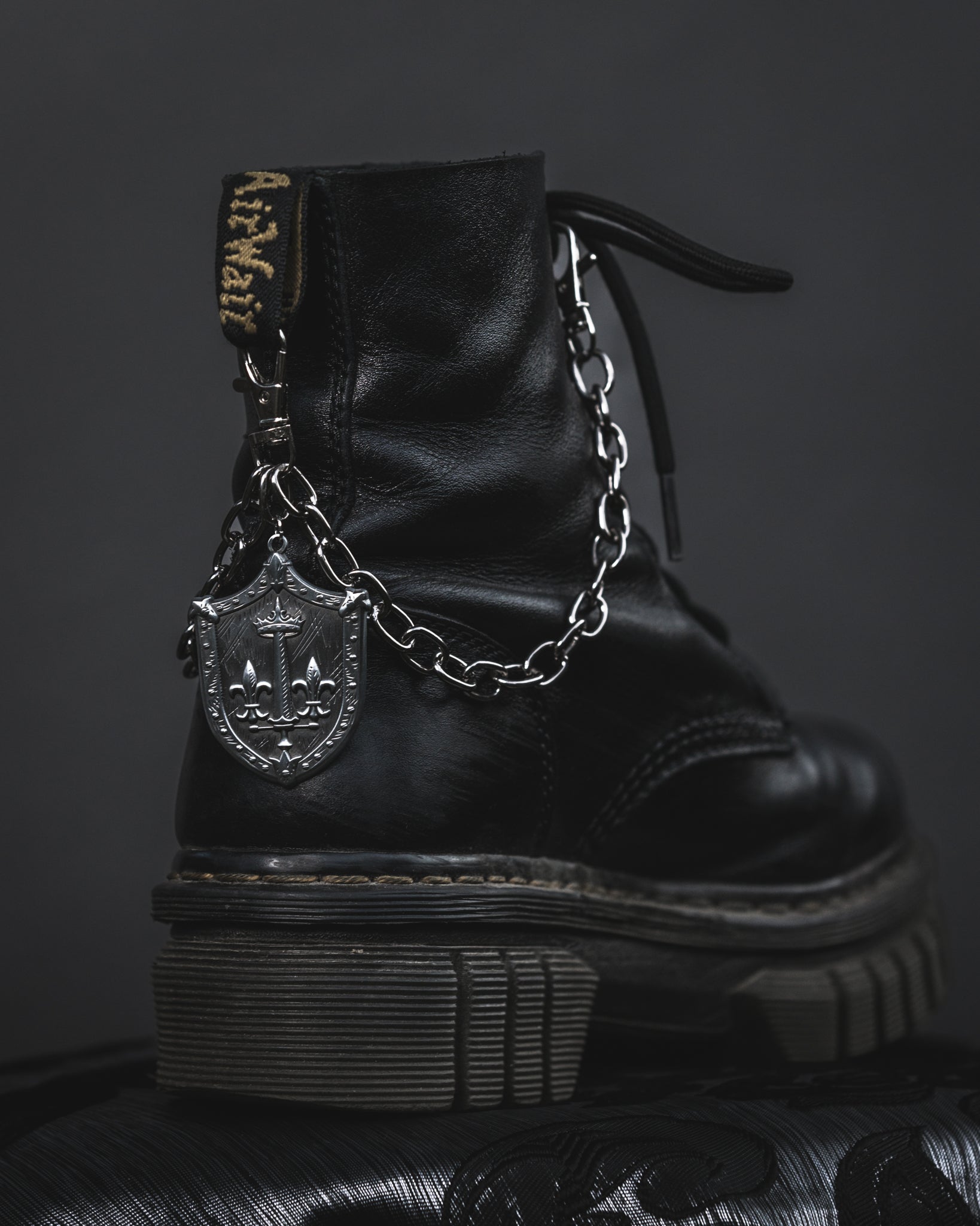 Close up of the Le Fay silver shield charm on the boot chain