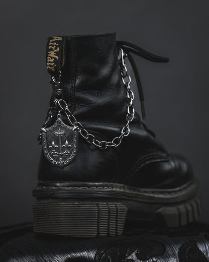 Close up of the Le Fay silver shield charm on the boot chain