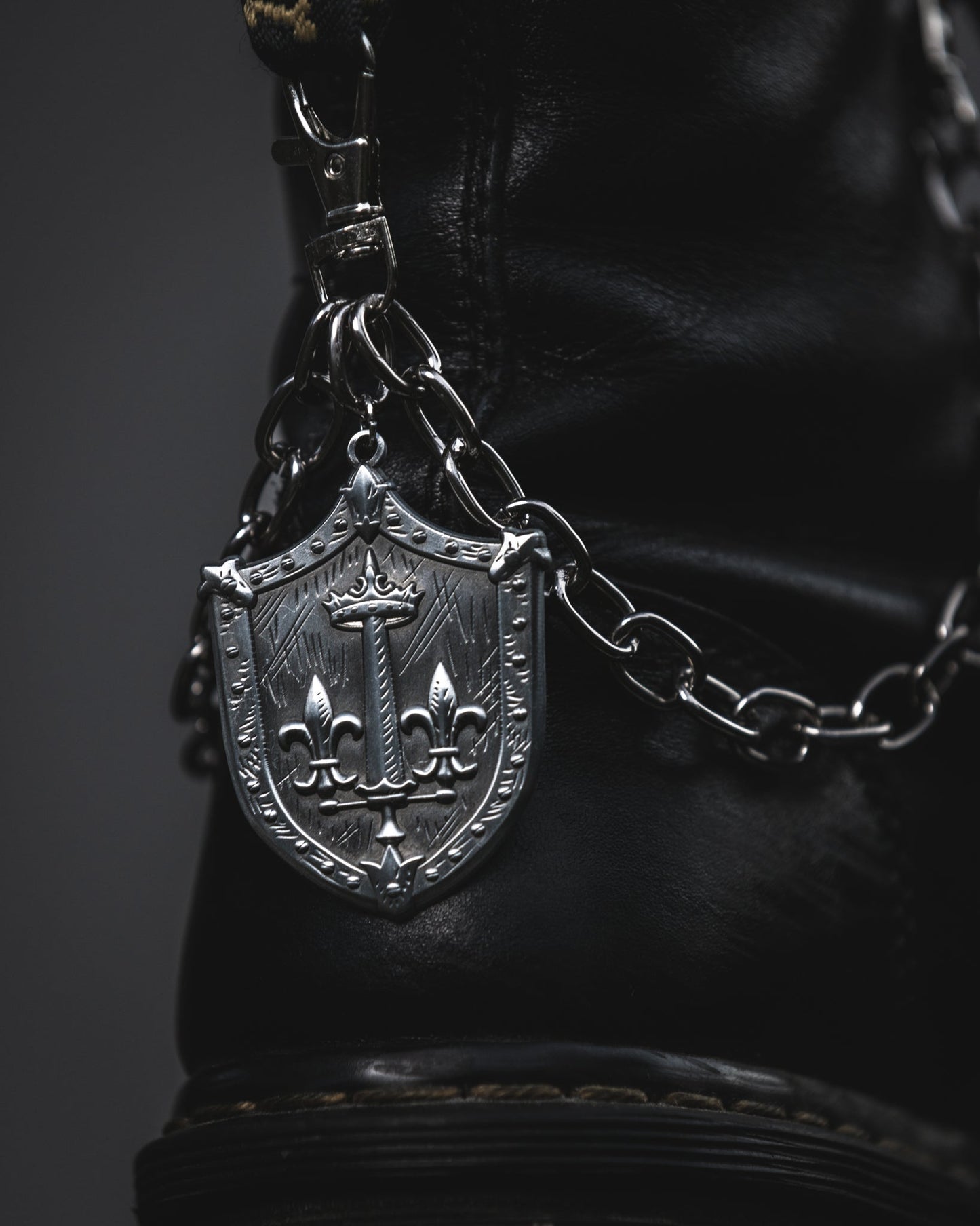 Silver Le Fay shield boot chain clipped to a black combat boot