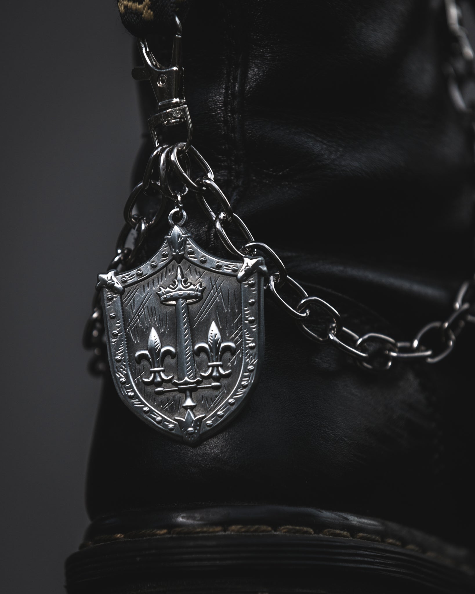 Silver Le Fay shield boot chain clipped to a black combat boot
