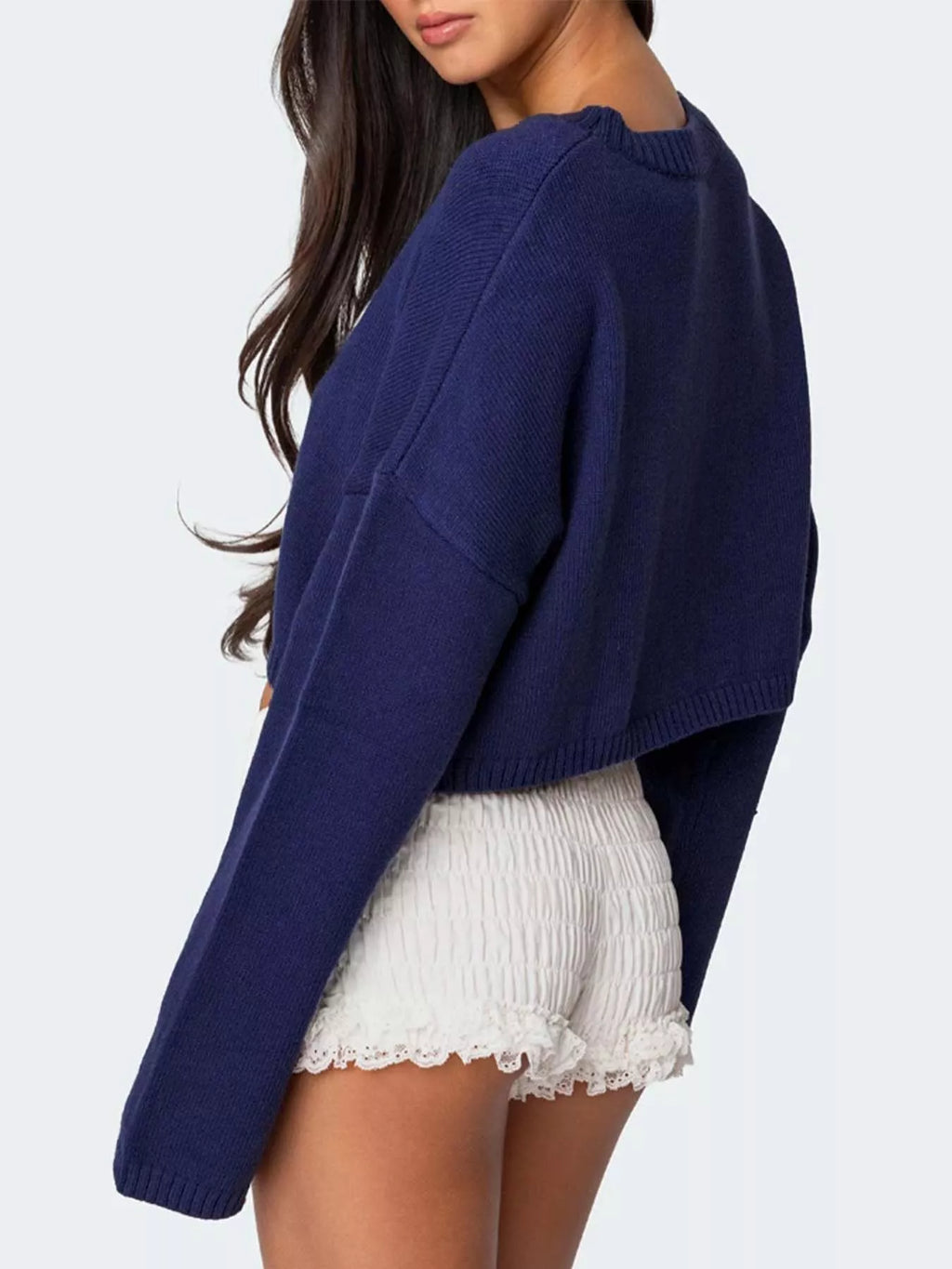 Close-up of the white bow on the navy blue cropped sweater