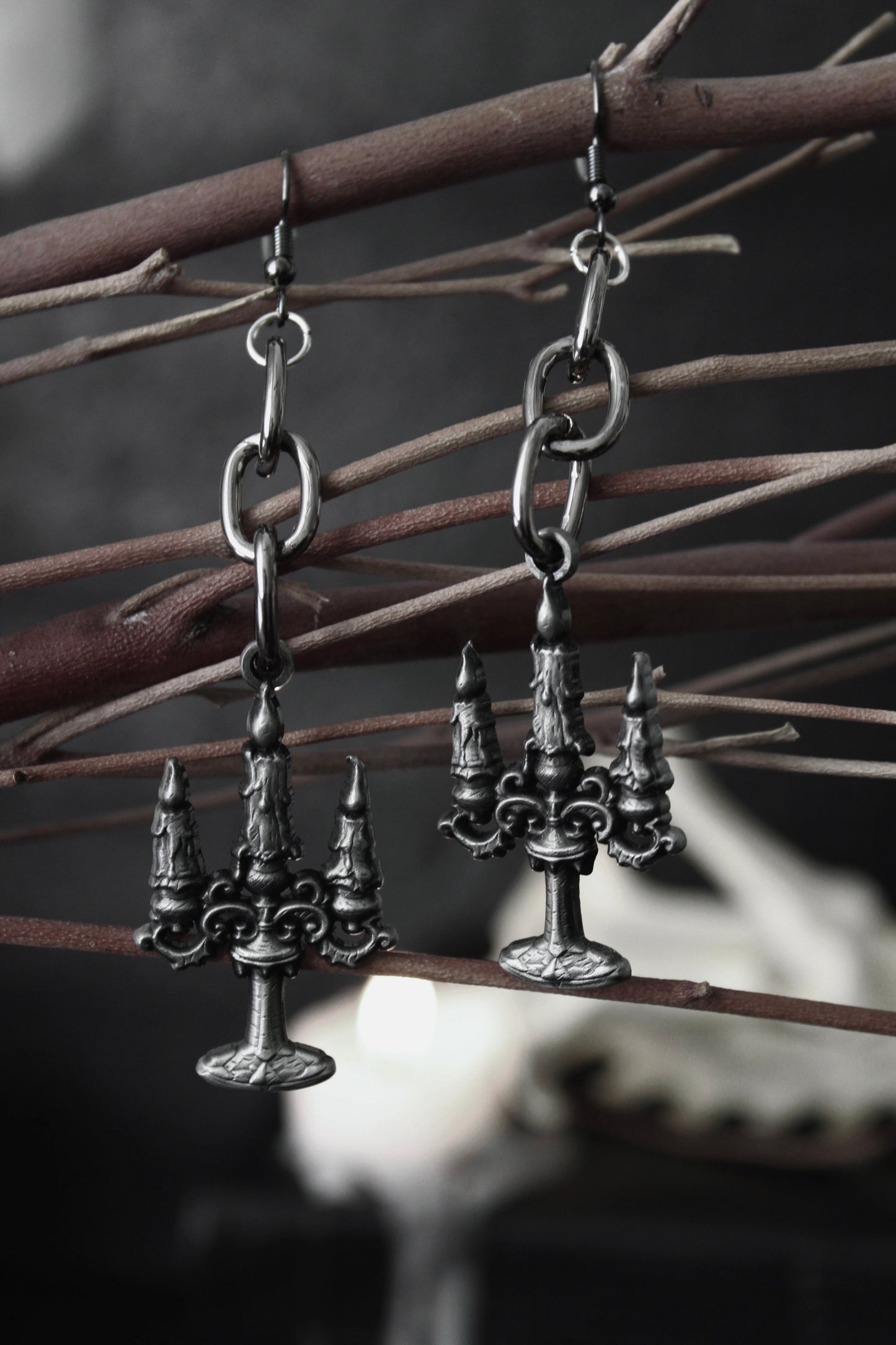 Blackened silver candelabra drop earrings hanging from oval chain links, by The Pretty Cult