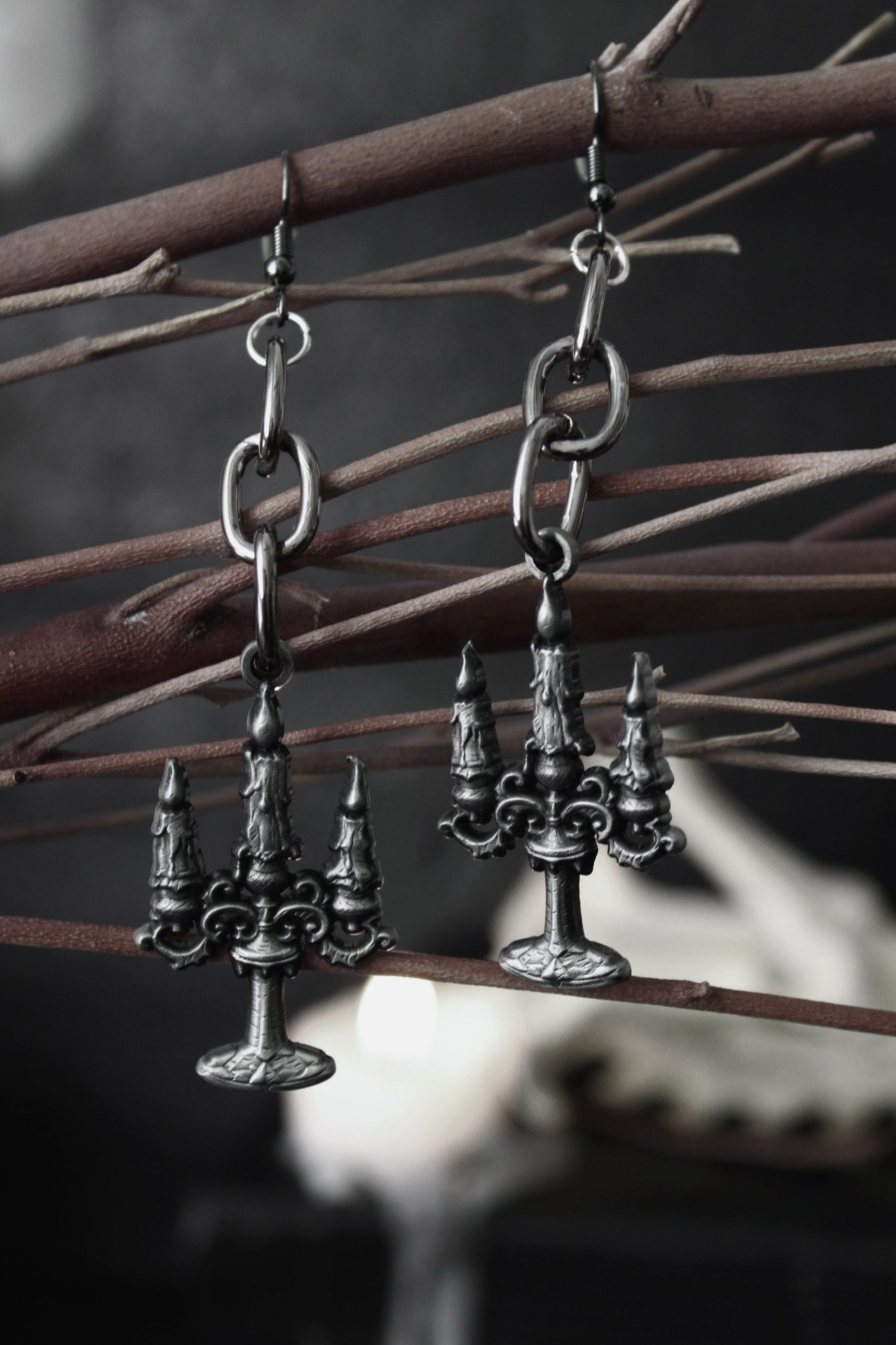Blackened silver candelabra drop earrings hanging from oval chain links, by The Pretty Cult