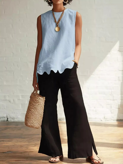 Odile scalloped hem sleeveless blouse in sky blue, styled with wide-leg trousers, by Pinup Girl Clothing