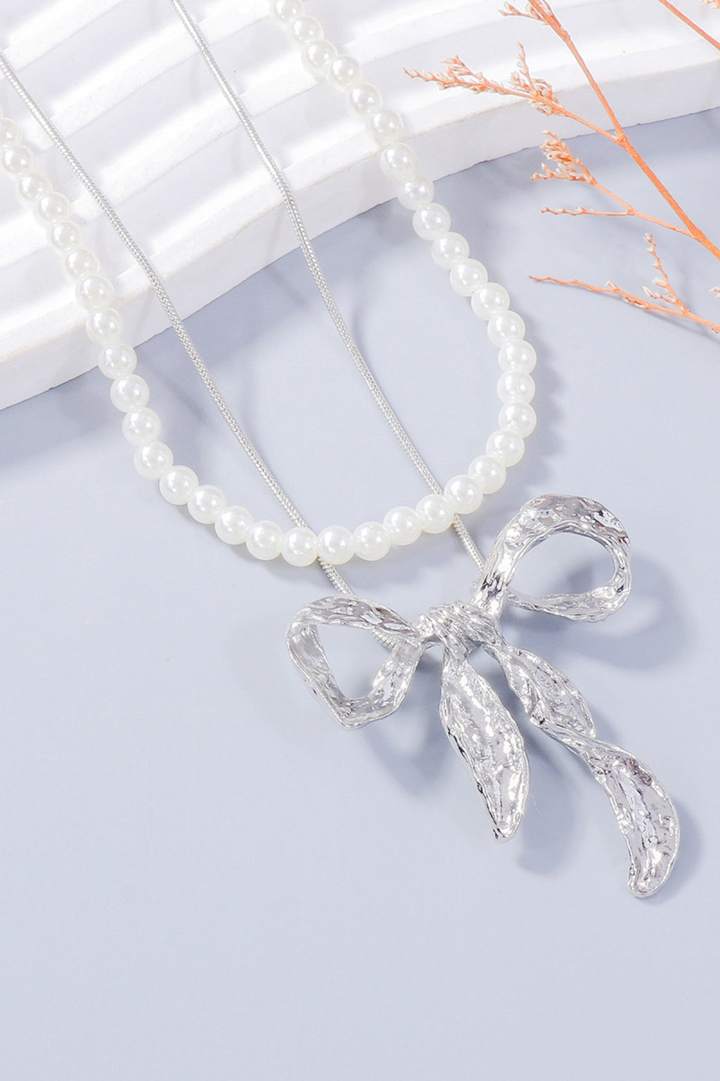 Zoe pearl necklace and bow earrings set in silver by Pinup Girl Clothing.