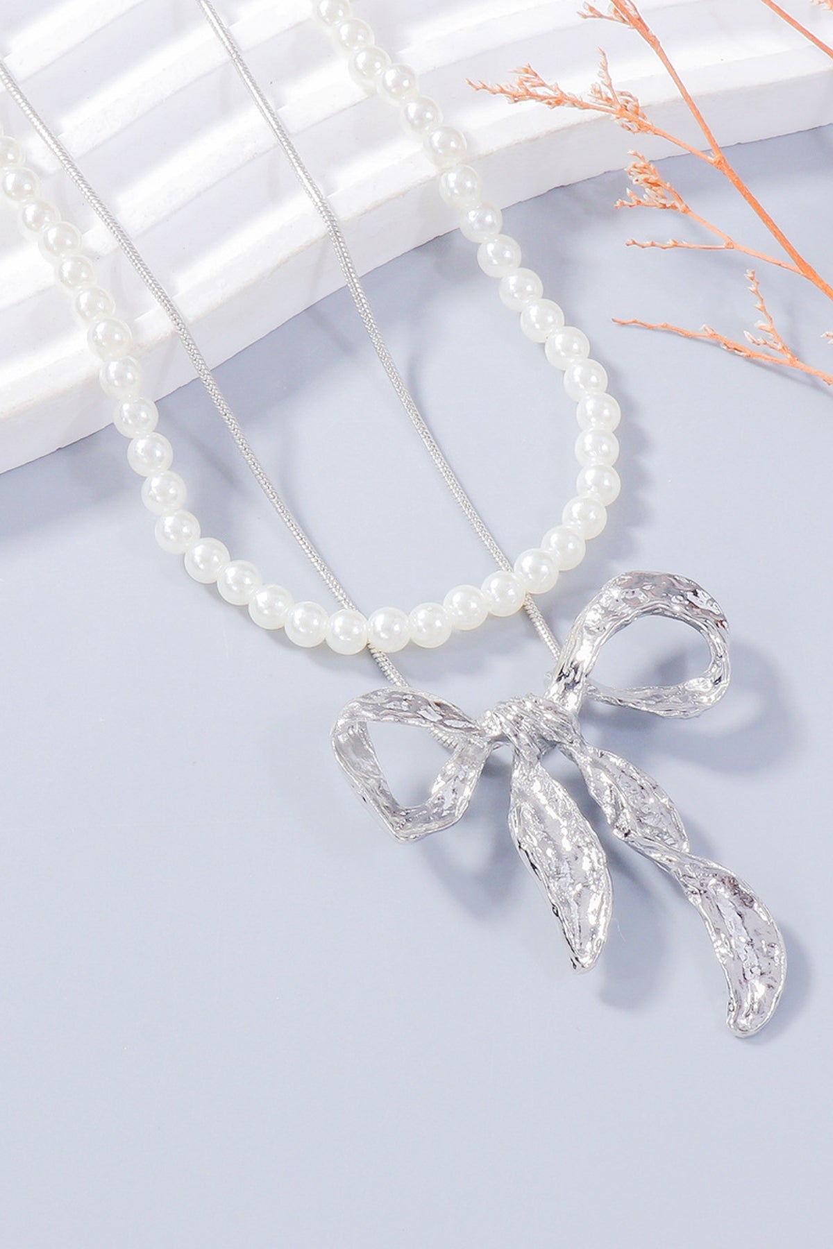 Zoe pearl necklace and bow earrings set in silver by Pinup Girl Clothing.