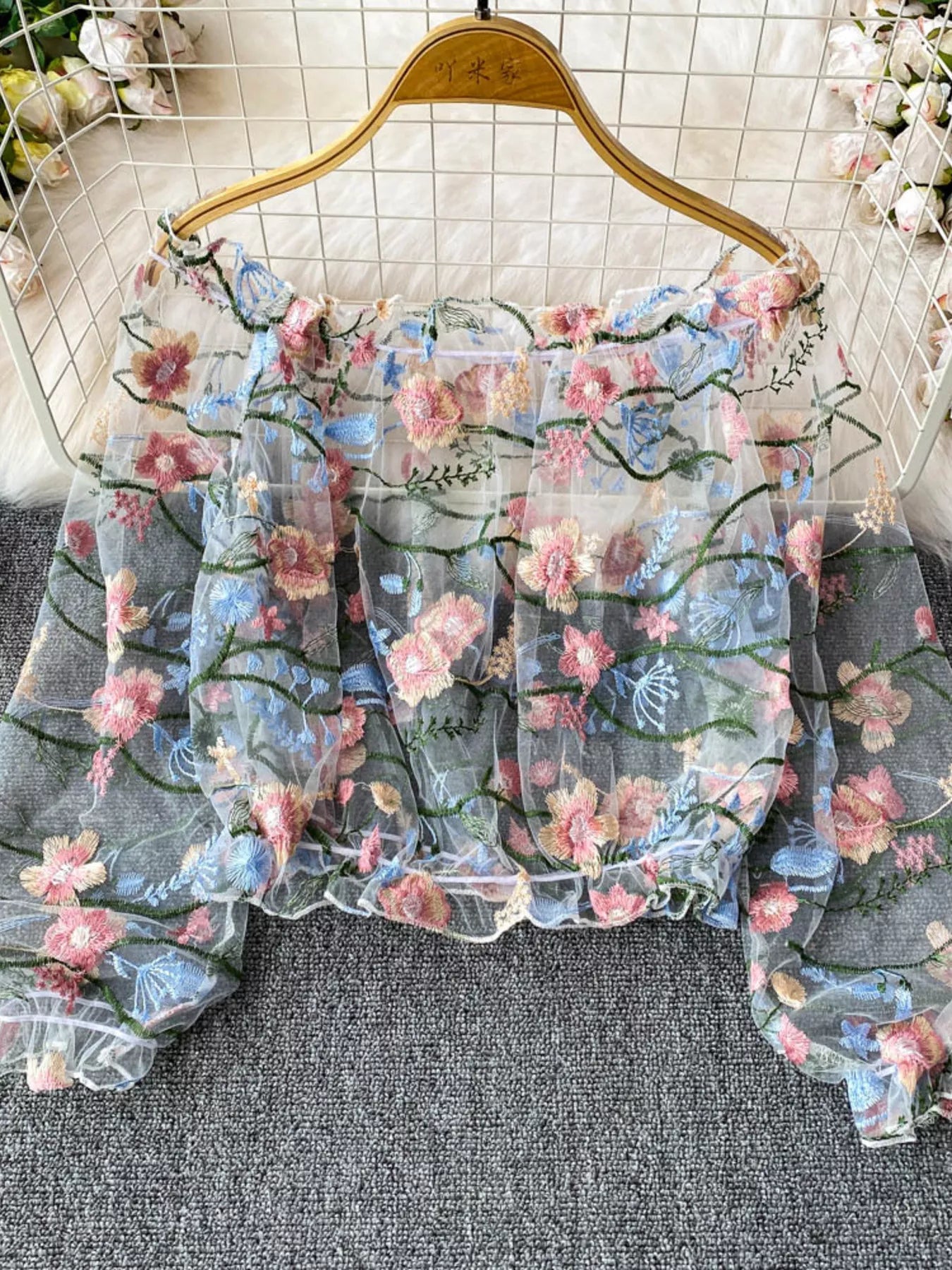Floral embroidered mesh off-shoulder top in light blue by Pinup Girl Clothing.