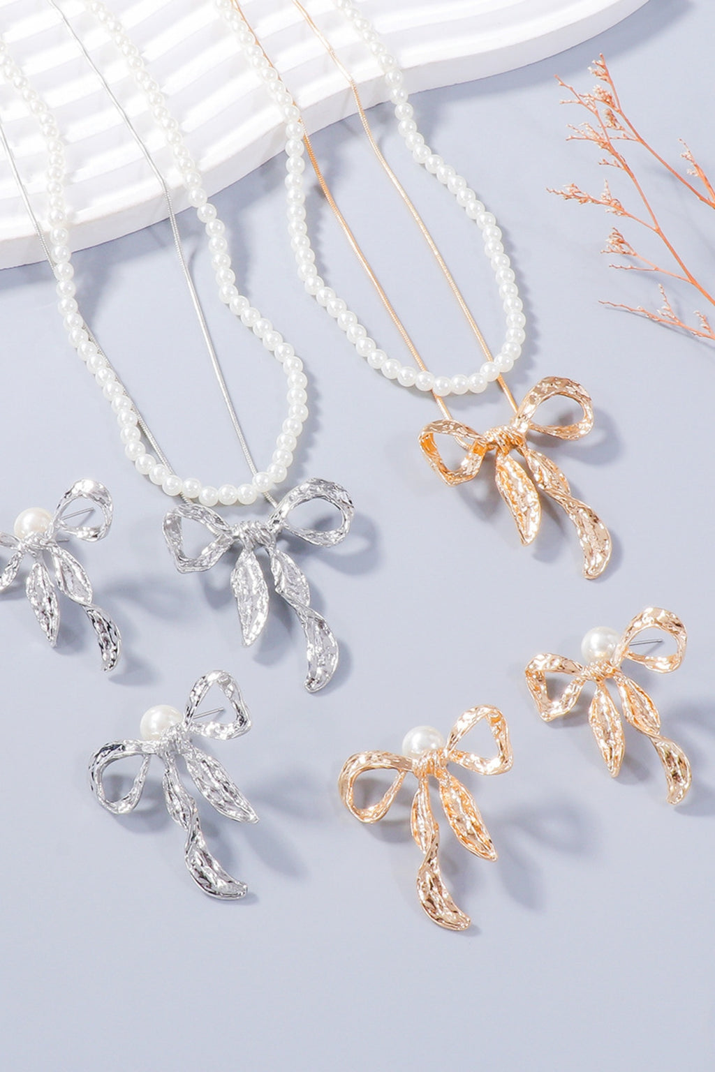 Zoe synthetic pearl necklace and bow earrings set by Pinup Girl Clothing, in silver or gold.