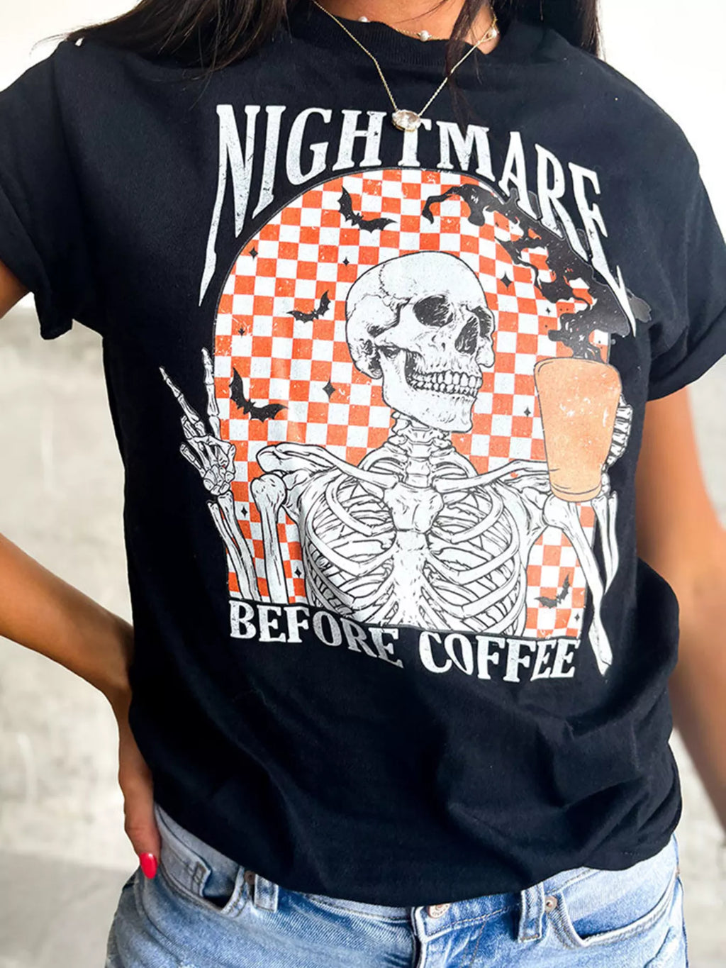 Close-up of the checkerboard skeleton print on the black graphic tee