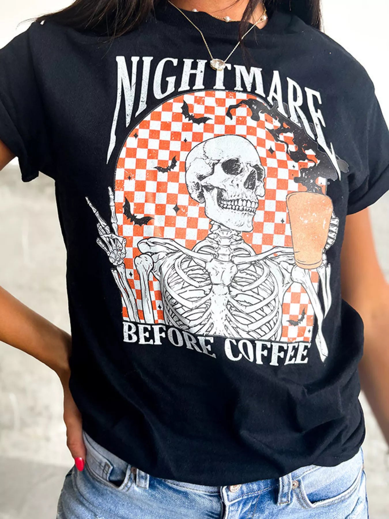 Close-up of the checkerboard skeleton print on the black graphic tee
