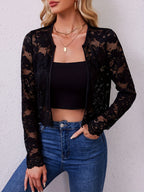 Model wearing the black sheer floral lace open front jacket over a black crop top with high-waisted jeans, front view