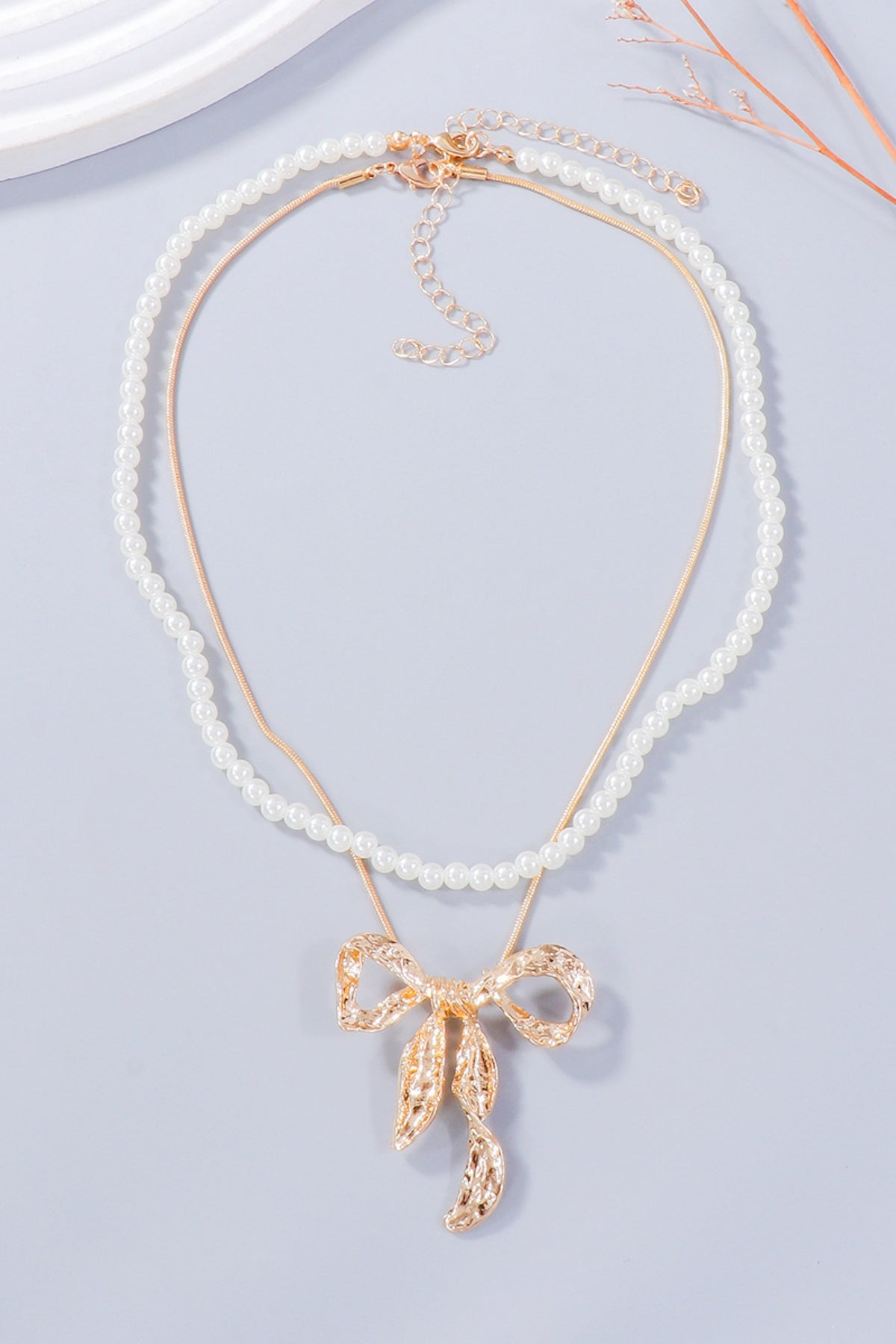 Zoe pearl necklace and bow earrings set in gold by Pinup Girl Clothing.