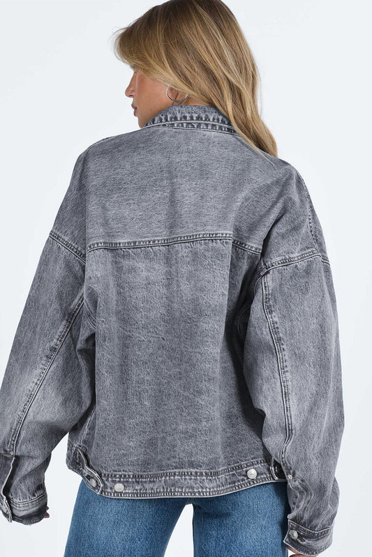 Grey drop shoulder denim jacket showing the metal buttons and chest pockets