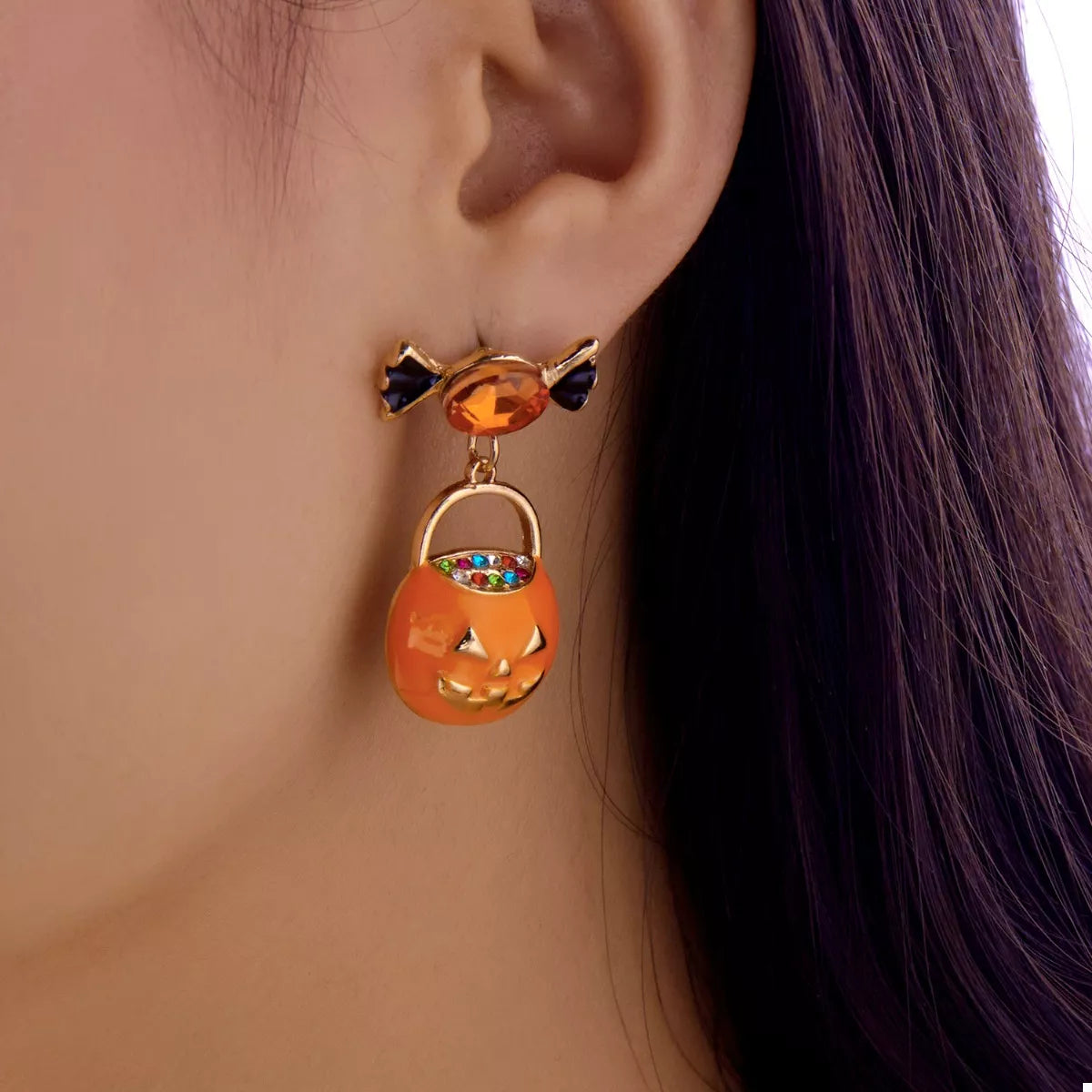 Orange rhinestone pumpkin drop earrings, close-up of the pave stones