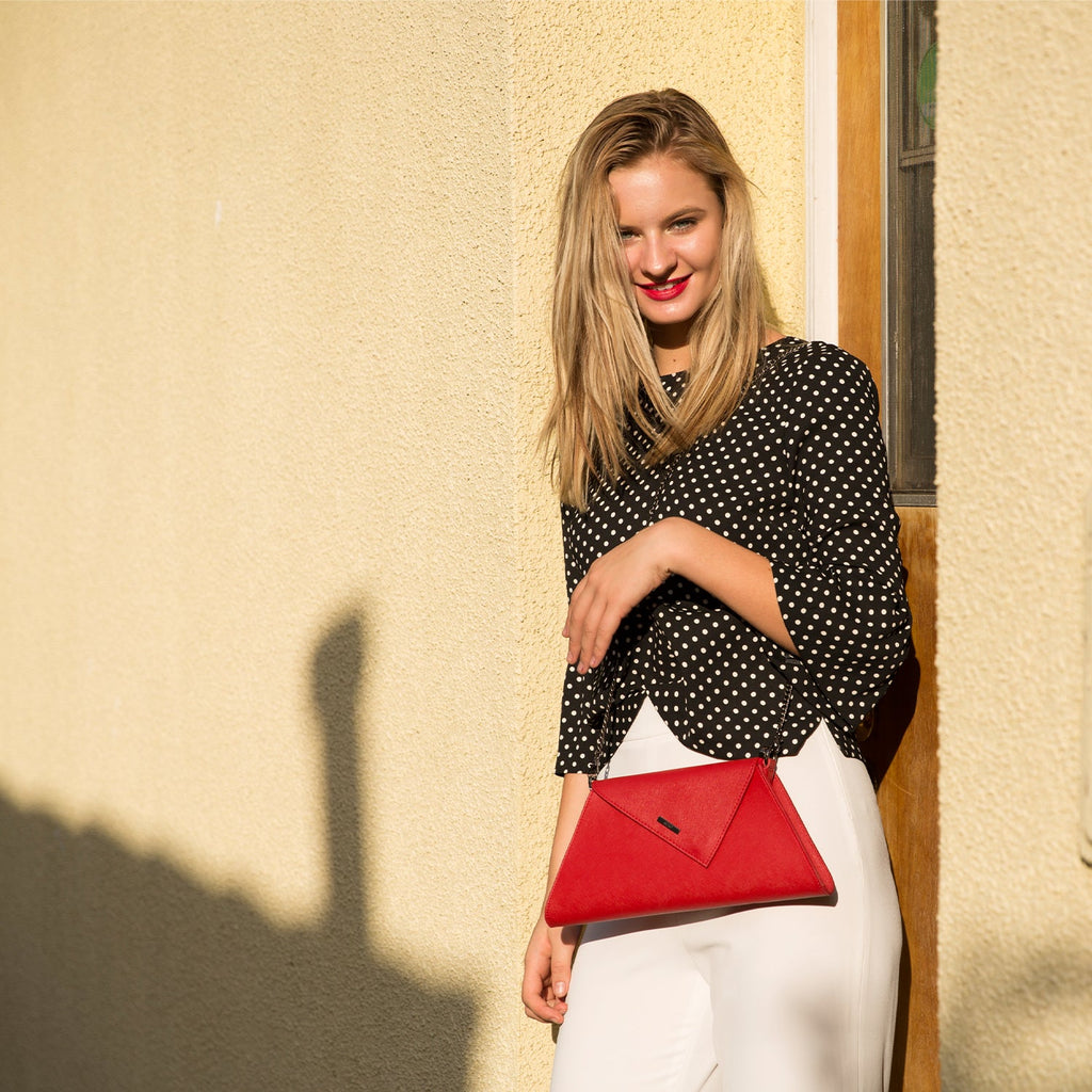Angelica red leather clutch carried by a model, another view, by Pinup Girl Clothing