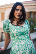 Model in the Amara swing dress in green and white Noto Tile print, with puff sleeves and a full swing skirt, by Pinup Girl Clothing