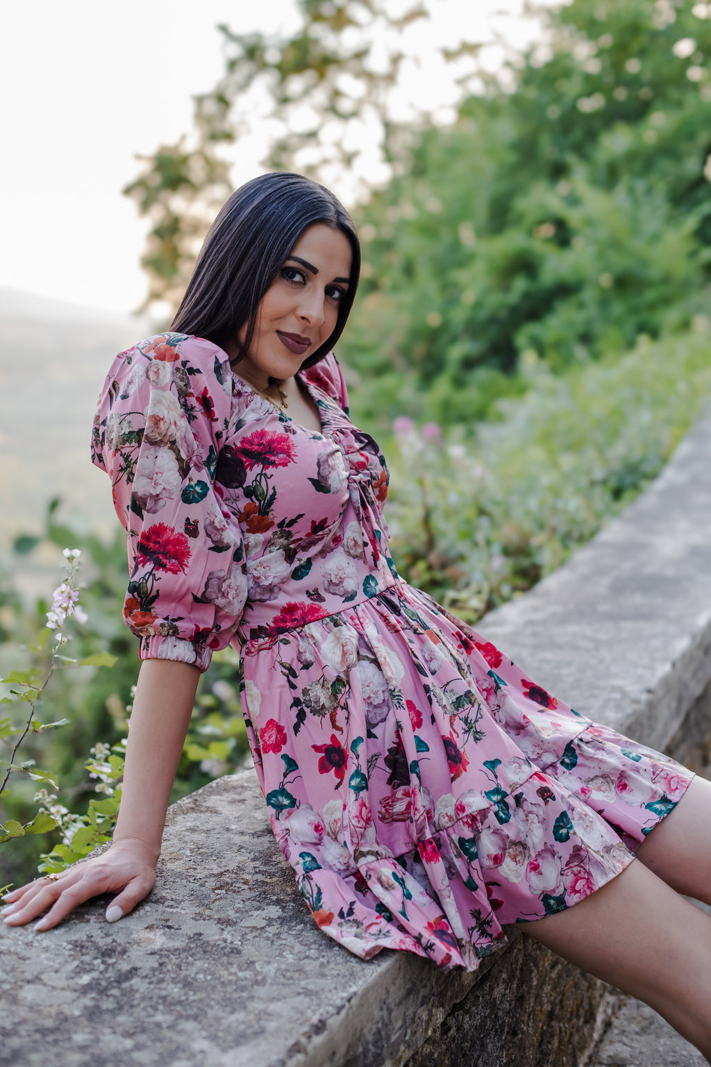 Model in the Molly Mini dress in Ambrosia Floral mauve pink, with the gathered Natalie bodice and long sleeves, by Pinup Girl Clothing