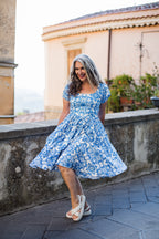 Model in the Amara swing dress in blue and white Noto Tile print, with puff sleeves and a full swing skirt, by Pinup Girl Clothing