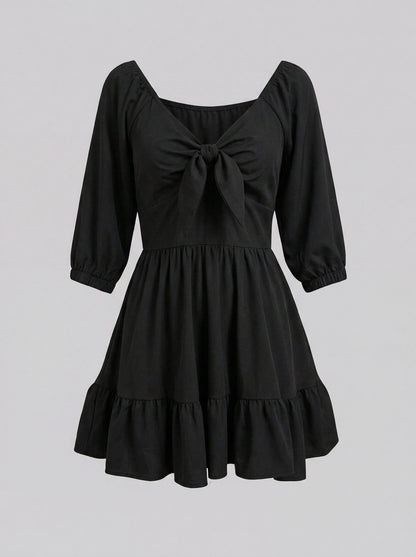 Ghost mannequin view of the Molly Mini dress in solid black, showing the tie-front bodice and tiered ruffle hem.
