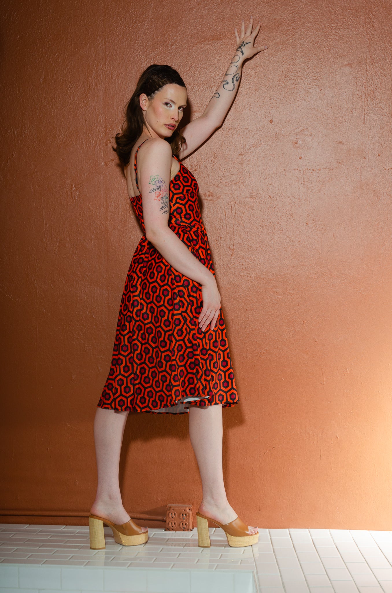 Side view of the Amalie Hotel Hexagon swing dress showing the fitted ballerina bodice, back zip and knee length gathered skirt