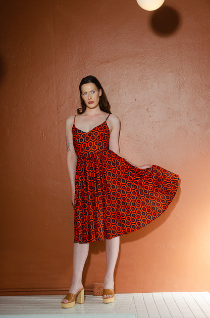 Model lifting the skirt of the Amalie Hotel Hexagon swing dress to show its full sweep and adjustable spaghetti straps