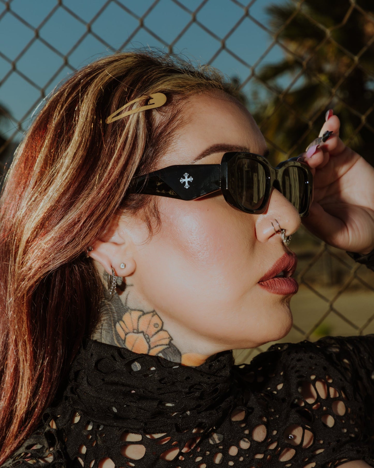 Model wearing the Deathray sunglasses in shiny black with a silver cross on the temple, by The Pretty Cult