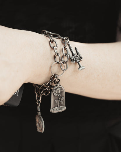 Close up of The Saint's Shadow silver charms on a delicate chain