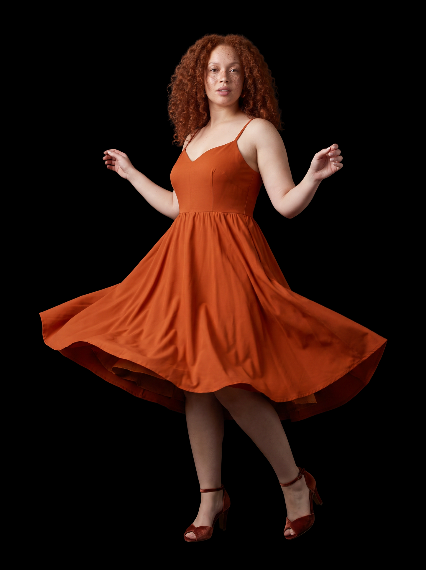 Amber Harvest Amalie swing dress against a black backdrop, skirt caught mid-twirl showing the full circle of the gathered skirt