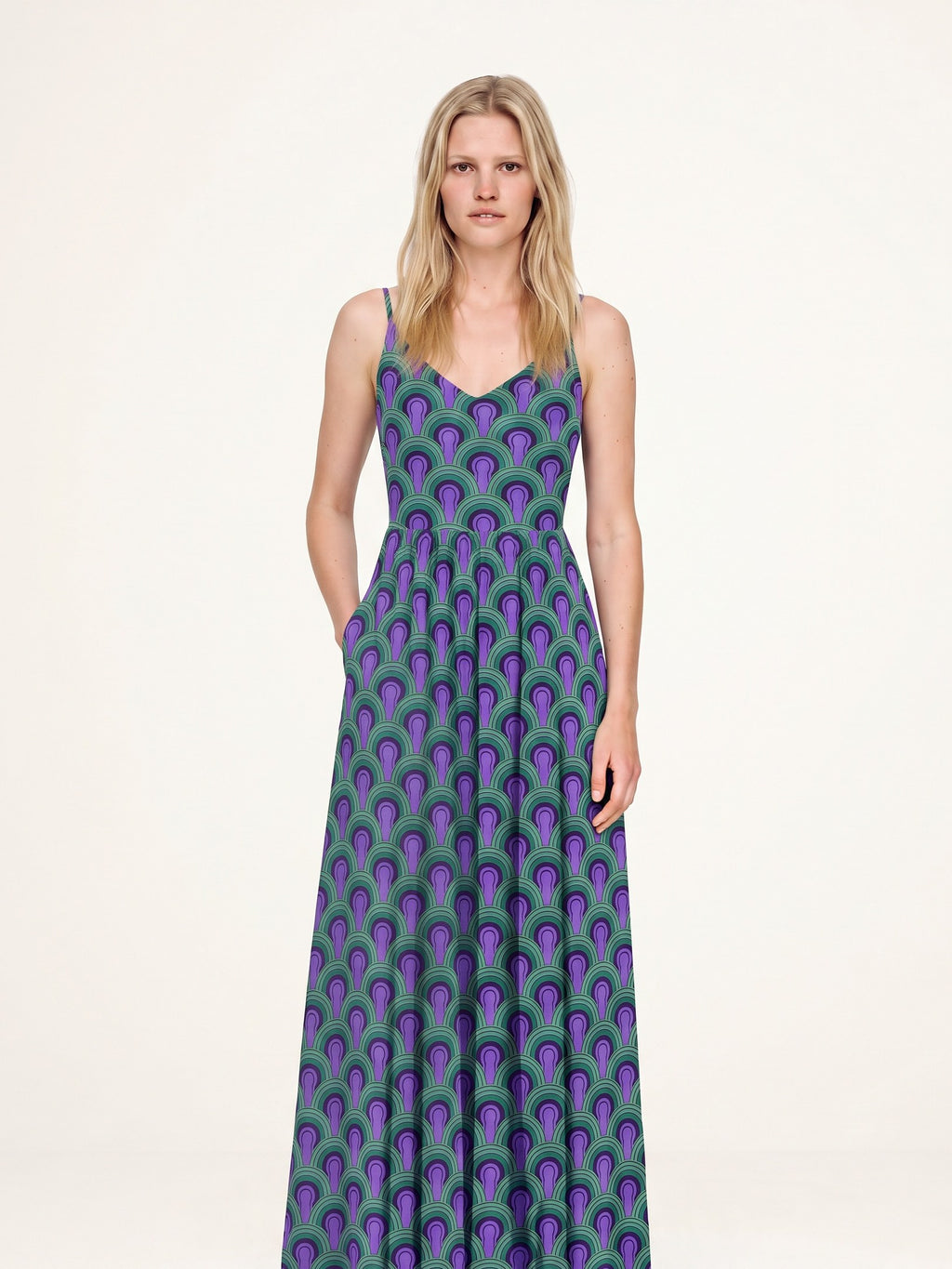 Amalie maxi dress in the Room 237 purple and green print, hand in the deep side-seam pocket, fitted ballerina bodice and gathered skirt
