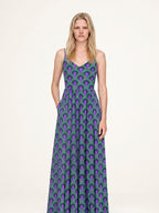 Amalie maxi dress in the Room 237 purple and green print, hand in the deep side-seam pocket, fitted ballerina bodice and gathered skirt