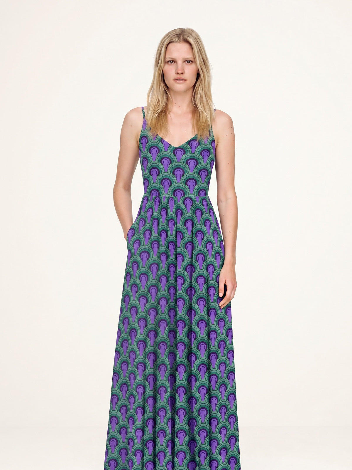 Amalie maxi dress in the Room 237 purple and green print, hand in the deep side-seam pocket, fitted ballerina bodice and gathered skirt