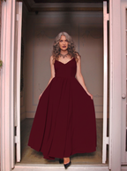 Burgundy Amalie maxi gown worn in a doorway, floor-length skirt falling to black heels