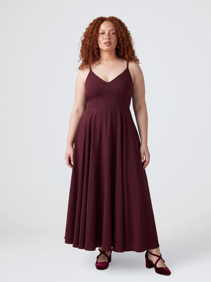 Model wearing the Amalie Ballerina maxi gown in burgundy, fitted 70s ballerina bodice with spaghetti straps and a gathered floor-length skirt