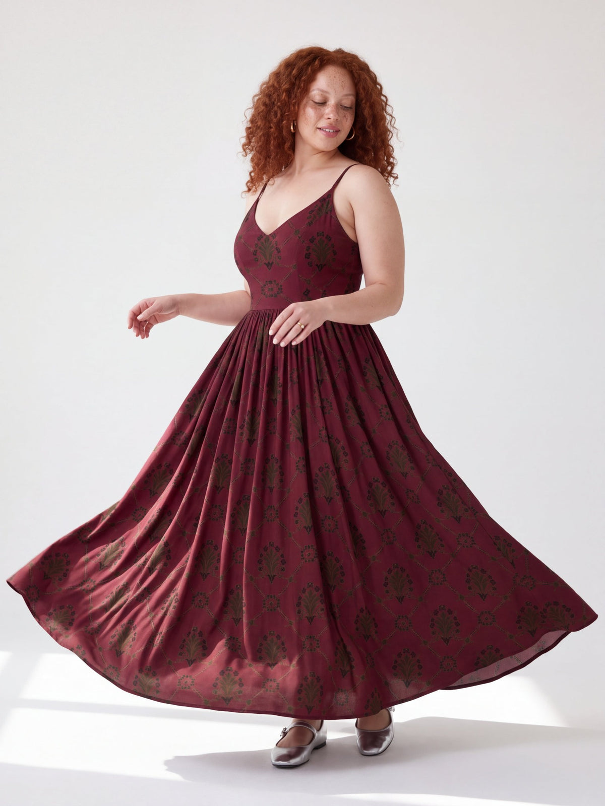 Model twirling in the Amalie Maxi in Goth Grand Trianon, eyes down, showing the full sweep of the gathered skirt