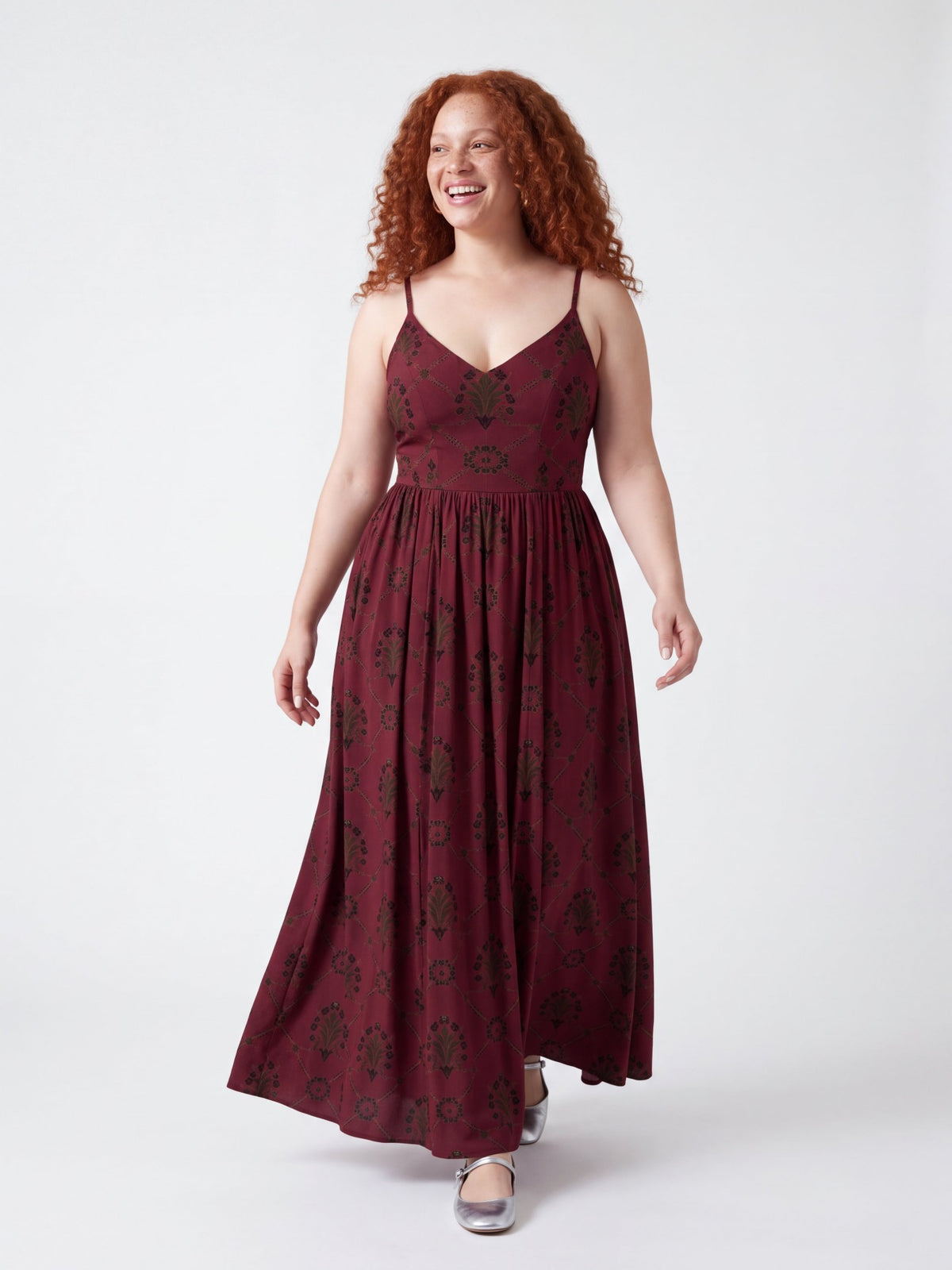 Model walking and laughing in the Amalie Maxi in Goth Grand Trianon, the gathered floor-length skirt moving with her